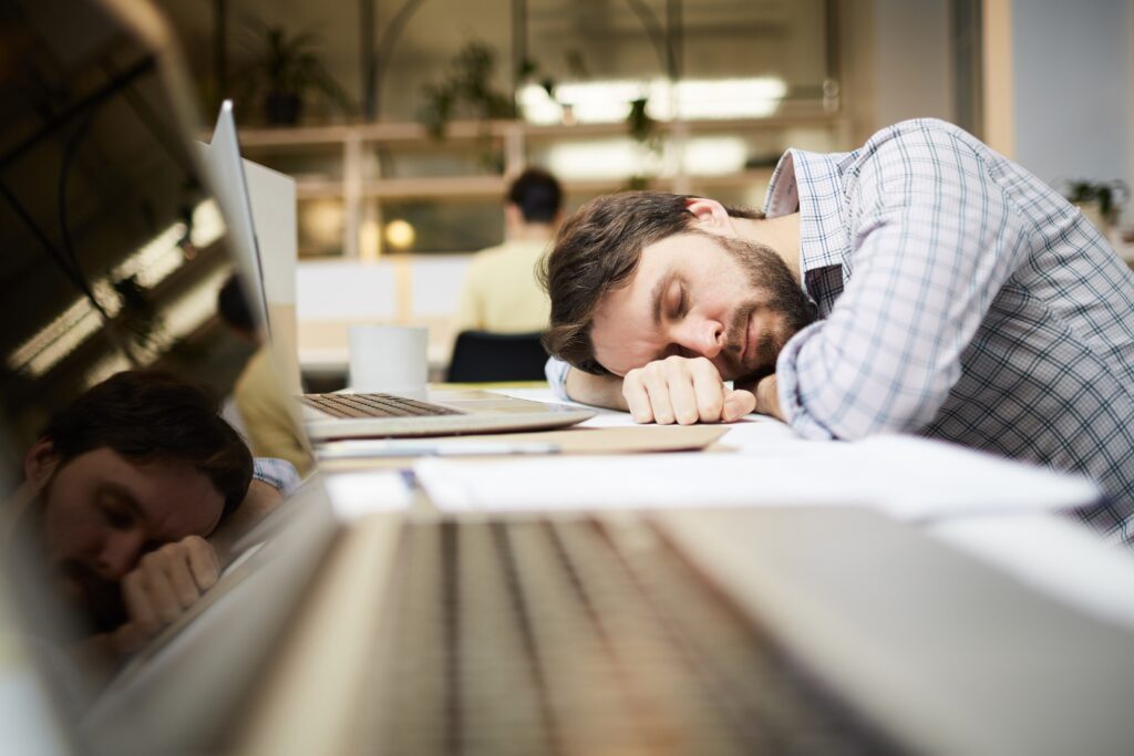 PCデスクで居眠りする男