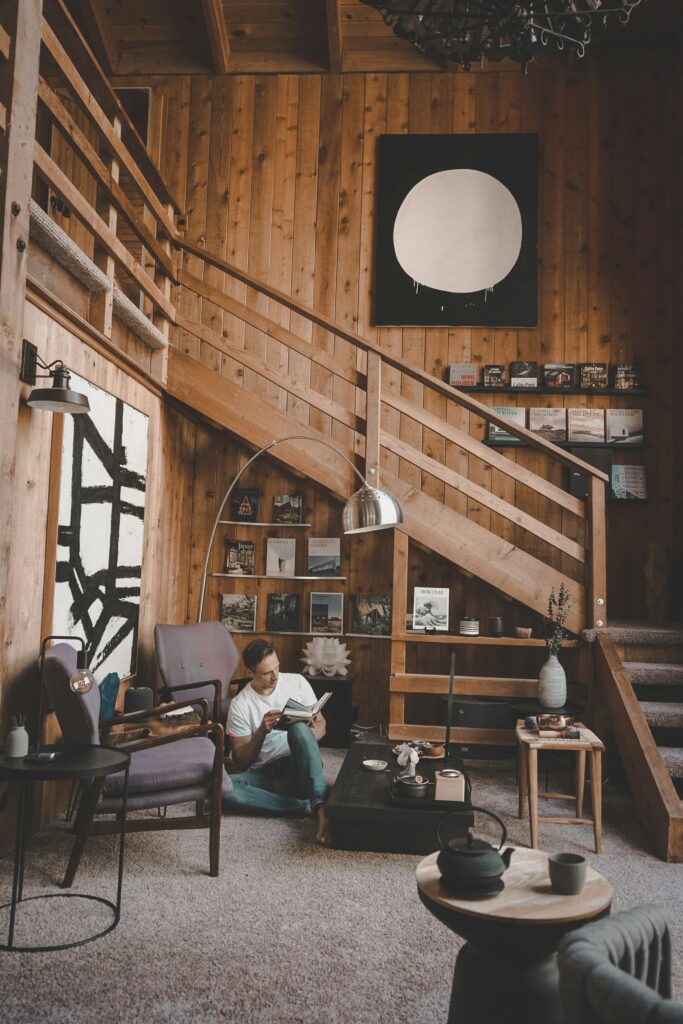 居心地の良い木造の部屋で本を読んでいる男。