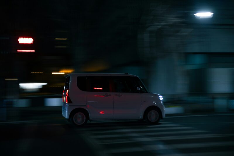 白い車が夜の通りを疾走している