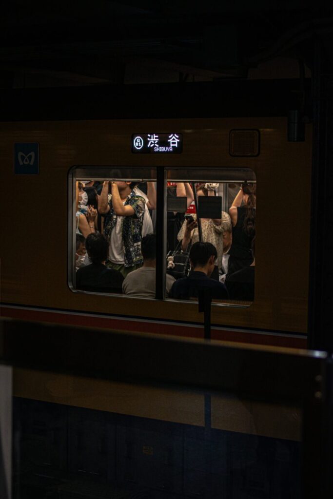 窓から乗客が見える混雑した車両。